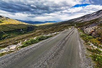 Gravel road through vast barren mountain landscape