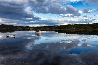 Boats and clouds reflected in the fjord