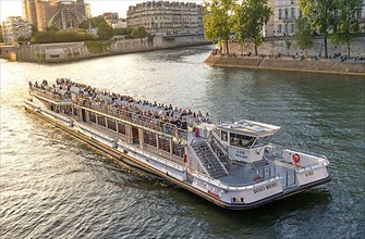 Tourist boat on the Seine at golden hour in Paris