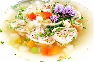 Delicious Braet Strudel soup served in a plate and garnished with chives and chive blossoms