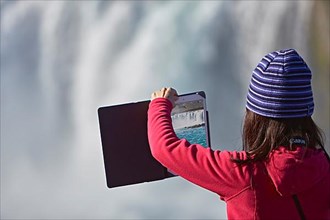 Young woman making panorama with tablet