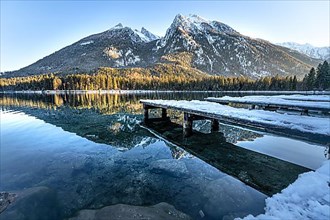 Footbridge with reflection in water at Hintersee in winter landscape