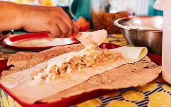 Hands making Nicaraguan Quesillo. Central American food the Quesillo