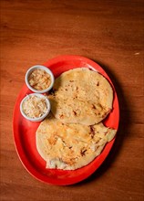 Closeup of Nicaraguan pupusas served on wooden table. Delicious traditional Salvadoran Pupusas with melted cheese on wooden table. Traditional pupusas served on a wooden table