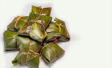 View of homemade Nicaraguan nacatamales with banana leaf on white background