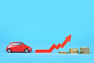 Small car with rising arrow and money coins on blue background
