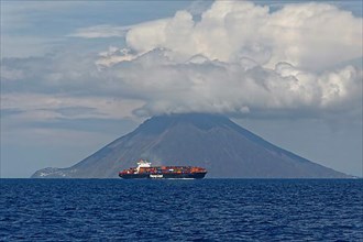 Container ship in front of Stromboli volcano and island