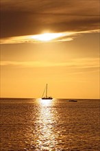 Sailing ship backlit at sunset