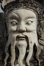 Wat Pho Chinese stone guardian face close up