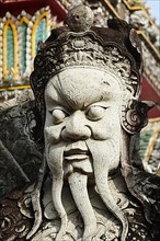 Chinese stone guardian statue close up in Wat Pho Buddhist Temple