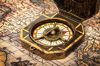 Vintage pirate retro compass close up on ancient world map