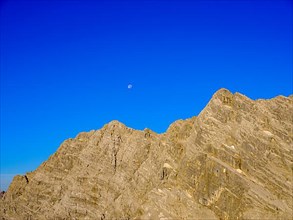 Upper part of the east face of the Watzmann with blue sky and full moon
