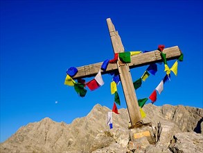 Buddhist prayer flags at the summit cross of the Kleiner Watzmann