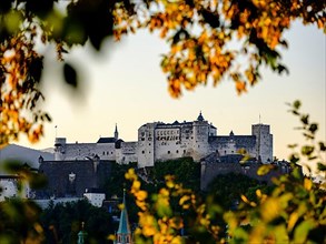 View through autumnal trees of Hohensalzburg Fortress
