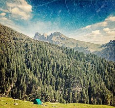 Vintage retro hipster style travel image of camp tent in Himalayas mountains with overlaid grunge texture
