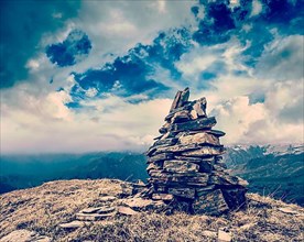 Vintage retro hipster style travel image of stone cairn in Himalayas mountains