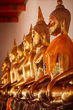 Row of sitting Buddha statues in Buddhist temple Wat Pho