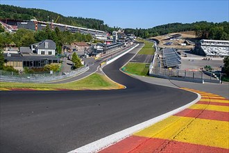 View from 40 metres high hilltop above the steep Raidillon driveway in the foreground to the dangerous Eau Rouge bend in the background of the Spa Francorchamps race track without racing cars