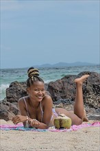 Young dark-skinned woman with bikini on the beach