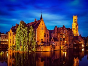 Famous view of Bruges- vintage retro effect filtered hipster style image of Belfry and old houses along canal with tree. Brugge