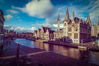 Vintage retro hipster style travel image of Ghent canal and Graslei street on sunset. Ghent