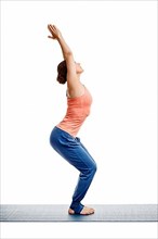 Sporty fit woman doing Surya Namaskar ashtanga vinyasa yoga asana Utkatasana