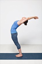 Beautiful sporty fit woman practices Sivananmda yoga asana Anuvittasana