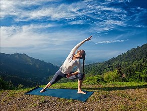 Sporty fit woman practices yoga asana Utthita Parsvakonasana