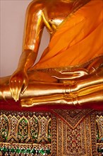 Sitting golden Buddha statue close up details. Wat Pho temple
