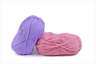 Balls of pink and purple wool on white background