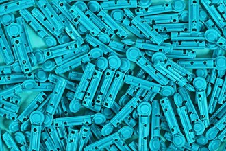Many blue disposable diabetes lancets used to draw blood for testing