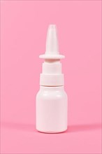 White nasal spray bottle on pink background