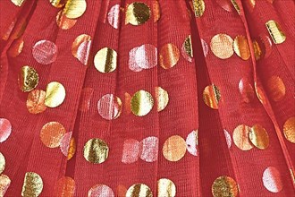 Tulle with golden polka dots on red fabric