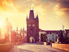 Vintage retro hipster style travel image of Charles bridge old town tower in Prague on sunrise