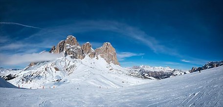 Panoramaof a ski resort piste with people skiing in Dolomites in Italy