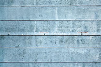 Gray blue wooden background with horizontal old planks and metal strip with nails