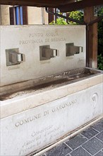 Public marble fountain with three taps in the village of Gargnano on the western shore of Lake Garda