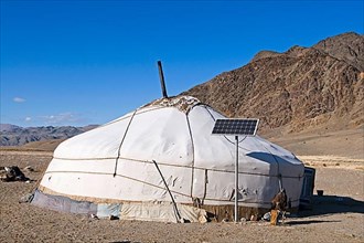 Kazakh nomad ger tent with solar panel and hooded Golden Eagle