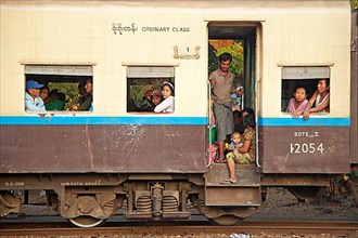 Burmese passengers in a normal class carriage of an old British train in Myanmar