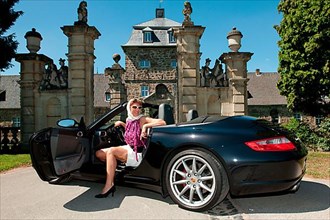 Woman with Porsche 911 cabriolet in front of castle