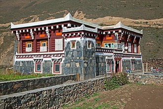 Traditional Tibetan architecture in the countryside with modern house with typical flat roof and small watchtower