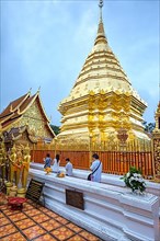 Worshippers walking around the Golden Chedi at Wat Doi Suthep
