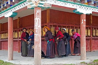Tibetan woman turning prayer wheels in Zhuqing village