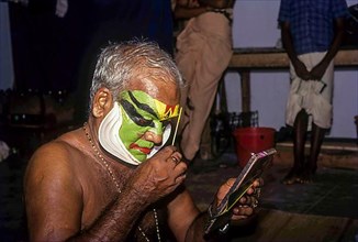 A Katakali artist applying makeup