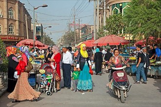 Uighur Muslim woman in Islamic dress in a shopping street in the city of Kashgar