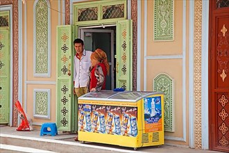 Shop window with traditional decorations and refrigerated cooler selling energy drinks in Kashgar city