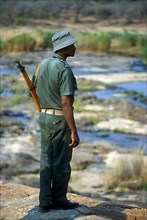 Black ranger armed with rifle patrolling Kruger National Park