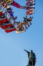 Excited thrillseekers have fun on the G Force funfair attraction at the travelling funfair