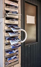 Mailboxes of the flat filled with advertising newspapers