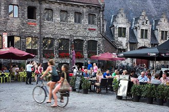 Tourists in street cafes in the historic centre of Ghent in summer
